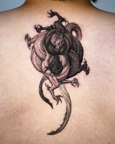 the back of a man's neck with a tattoo design on it, depicting a snake