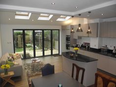 an open kitchen and living room with sliding glass doors