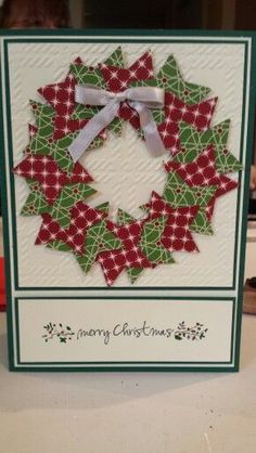 a christmas card with a green and red wreath