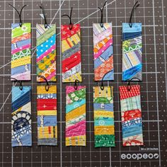 four bookmarks made out of strips of fabric on top of a piece of paper