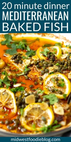 a pan full of mediterranean baked fish with lemons and capers