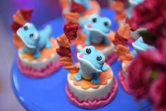 some little blue and orange cupcakes on a table