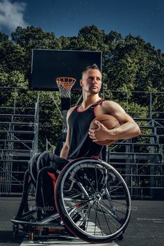 a man in a wheelchair with his arms crossed and basketball hoop behind him - stock photo - images