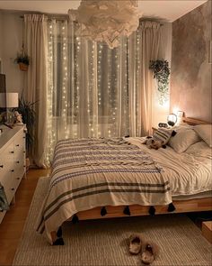 a bed room with a neatly made bed and lights on the window sill above it