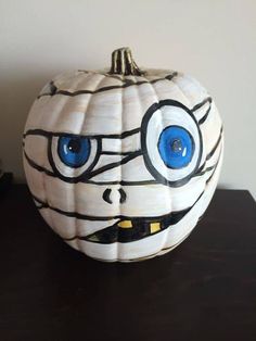 a white pumpkin with blue eyes painted on it