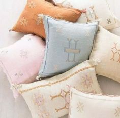 four pillows with different designs on them sitting next to each other