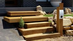 wooden steps leading up to the side of a building with grass and rocks around them