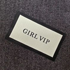 a black and white label with the word girlup on it sitting on a carpet