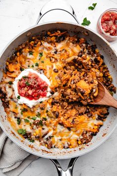 a large skillet filled with taco and sour cream on top of a table