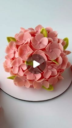 the cake is decorated with pink flowers and green leaves