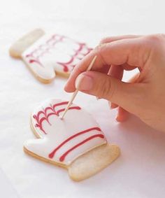 someone is decorating some cookies with icing on the top and one has a toothpick in it