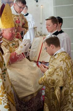 a group of men standing next to each other in front of a priest holding an open book