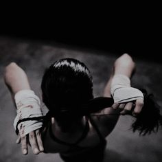 a woman with her hands in the air while wearing white gloves and black tank top