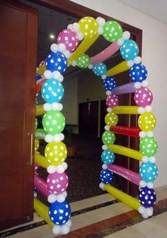 an arch made out of balloons with polka dots on the top and bottom, in front of a door