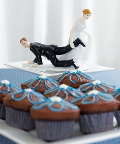 two figurines sitting on top of each other in front of some chocolate cakes