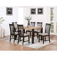 a dining room table with six chairs and a rug