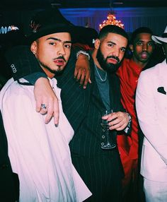 three men in suits and hats are posing for a photo at a party with one man holding his arm around the other