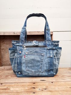 a blue jean purse sitting on top of a wooden table next to a white wall