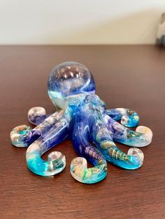 an octopus figurine sitting on top of a table next to some glass beads