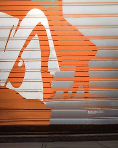 an orange and white painting on the side of a garage door