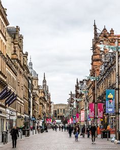 people are walking down the street in an old city