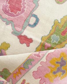 a close up view of a pink and yellow floral print fabric with an ornate design on it