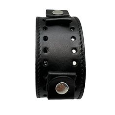 Item: BK-k Cuff Style: Junior Cuff Type: Buckle Cuff Material: Patent Leather Band Cuff Length (With Buckle): 9.5" Band Cuff Width: 1.5” Band Cuff Holds: 20-22 Millimeters Watch Cuff Color: Black Black Leather Punk Wristband, Black Punk Leather Bracelet Fashion Accessory, Black Punk Style Leather Bracelet, Punk Style Leather Cuff Bracelet With Wrist Strap, Black Leather Strap Punk Bracelets, Black Leather Wristband With Bracelet Strap, Adjustable Black Band Punk Cuff Bracelet, Adjustable Black Watch Band With Wrist Strap, Leather Cuff Bracelets With Black Band