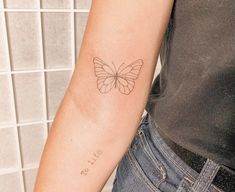 a woman with a butterfly tattoo on her arm and the word butterflies written in cursive writing