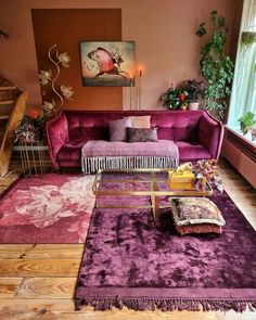 a living room with purple couches and rugs