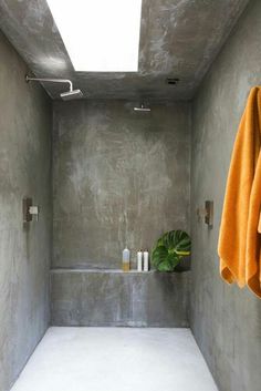 a bathroom with concrete walls and white flooring