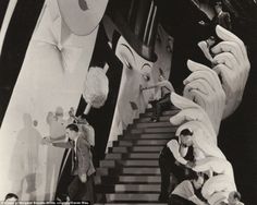 an old black and white photo of some people on the stairs with their hands in front of them