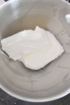 a metal bowl filled with whipped cream on top of a stove