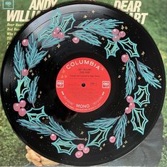 an old record with blue and pink decorations on it's side in front of a magazine