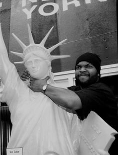 a man standing next to a statue of liberty