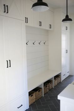 a kitchen with white cabinets and black tile flooring