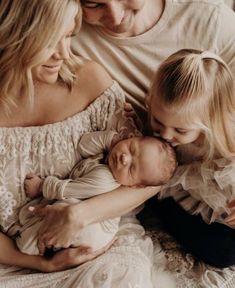 a woman and two girls are holding a baby