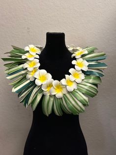 a black mannequin with white and yellow flowers on it's neckline