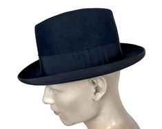 This is a beautiful quality homburg styled fedora hat in a deep blue colour, almost black.  The lining bears the Eatonia brand mark and the sweatband is gold stamped with "The T. Eaton & Co. Limited of Montreal Canada".  The hat is of excellent quality and was probably made under contract by one of the better hat makers, most likely Biltmore of Canada or Stetson.  The inventory ticket under the sweatband of this homburg states that it is a size 7 1/4 and the size ticket at the back sweatband reads "1/4".  Due to the higher crown, I believe that this dates the hat to the late 1940s or early 1950s.  Note that the price ticket on the interior of the sweatband reads $4.75, which, to me, is more in keeping with 1940s.   This hat is made in a classic homburg form with turned rim covered in grosg Vintage Formal Hat Bands, Formal Top Hat For Kentucky Derby, Vintage Formal Hat Bands In Solid Color, Navy Formal Hat With Curved Brim, Navy Curved Brim Formal Hat, Classic Hat Bands For High Crown Hats, Classic Formal Top Hat, Classic Formal Felt Hat With High Crown, Winter Formal Fedora With High Crown