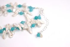 Dive into a sea of serenity with this Ocean Breeze necklace. The two strands of white Biwa pearls symbolize femininity and purity, while the matte turquoise rounds add a touch of color and vibrancy. Swarovski© crystal adds a touch of sparkle, making this necklace perfect for all occasions. The silver adjustable chain makes it easy to customize the length, so you can wear it any way you like. Soak up the sun and feel the sand between your toes while wearing this beautiful piece of jewelry. Turquoise Pearl Necklace With Pearl Drop, Elegant Turquoise Beaded Necklaces For Weddings, Elegant Double Strand Turquoise Beaded Necklace, Elegant Turquoise Double Strand Beaded Necklaces, Elegant Turquoise Multi-strand Jewelry, Elegant Multi-strand Turquoise Jewelry, Elegant Turquoise Pearl Drop Necklace, Elegant Turquoise Beaded Necklaces With Pearl Chain, Elegant Multi-strand Turquoise Beaded Necklaces