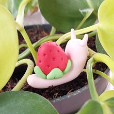 a toy snail is laying on top of a plant