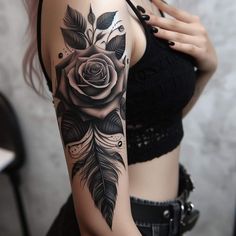 a woman with a rose and feather tattoo on her arm