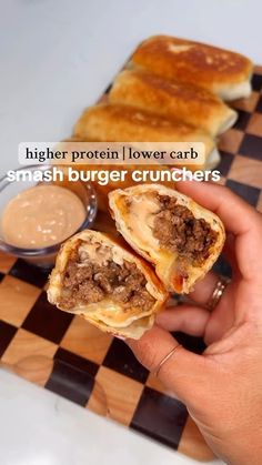 a person is holding up some food on a checkerboard board with the words, higher protein lower carb smash burger crunchers