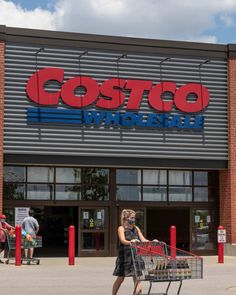 a woman pushing a shopping cart in front of a store