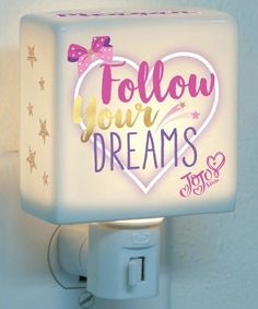 a night light with the words follow your dreams on it and a pink heart in the center