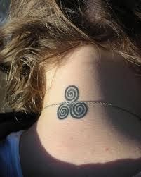 a woman's neck with a tattoo on the back of her neck and an ornamental design