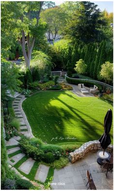 a backyard with grass and stone steps leading up to the back yard, surrounded by trees