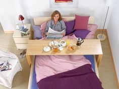 a woman sitting on a couch reading a newspaper