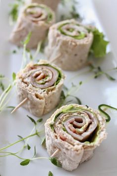 some food is on a white plate with green garnishes and other items