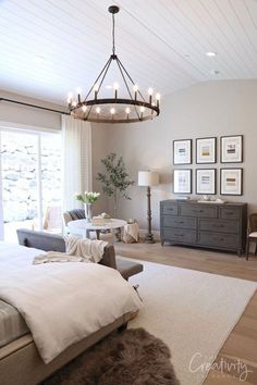 a bedroom with a bed, dresser and chandelier