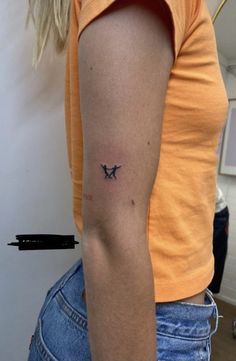 a woman with a small airplane tattoo on her arm